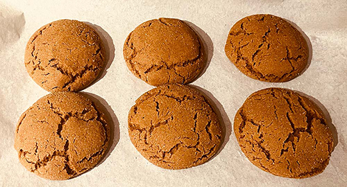 Image of gingersnap cookies on baking sheet, having finished baking